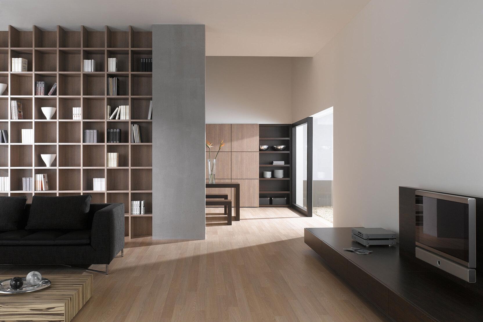 Offene Wohnraumimpression mit Einbauregal in Trennwand Offene Wohnraumimpression mit Einbauregal für Bücher und Dekoration in Trennwand mit hellem Holzboden